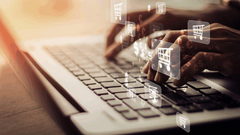 Pessoa digitando em um notebook com ícones de carrinho de compras flutuando na tela, representando operações digitais e gestão financeira no comércio; conceito ligado à tributação no varejo e ao controle fiscal em ambientes de e-commerce.
